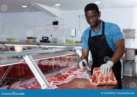 Confident African American Male Butcher Cutting Fresh Meat In Butcher