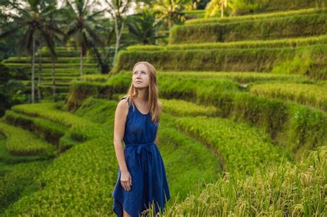 Mujer joven en la plantación de campo de arroz en cascada verde en la