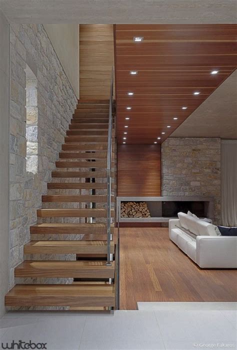 Open And Light Staircase With Warm Wood And Stone Fireplace