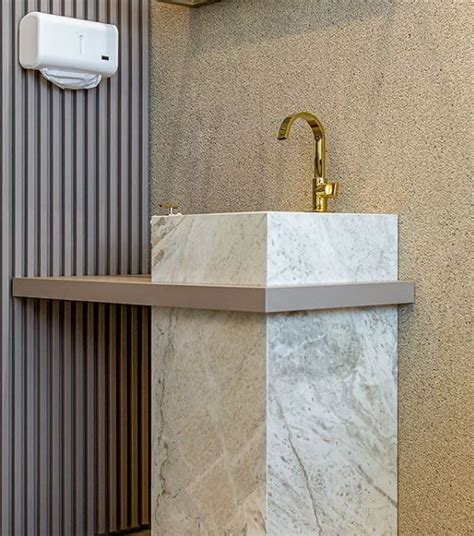 A Bathroom Sink Sitting Under A Faucet Next To A Wall Mounted Soap