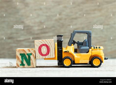 Toy Forklift Hold Letter Block O To Complete Word No On Wood Background