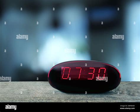 Digital Clock Showing 730 Oclock On Wooden Table Night Background