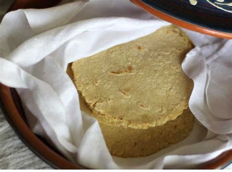 Two Tortillas Sitting On Top Of A White Paper In A Brown And Blue Plate