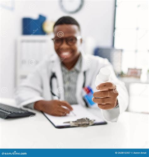 Young African Man Working As Doctor Writing Pills Prescription At