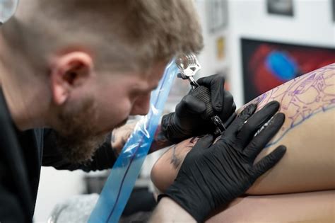 Gros Plan De L Artiste Masculin De Tatouage Barbu Fait Un Tatouage Sur