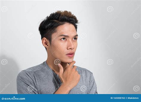 Portrait Of Troubled Young Asian Guy Trying Think Up Plan Or Idea