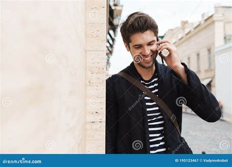 Imagem Do Homem Feliz Falando No Celular Enquanto Se Inclina Na Parede