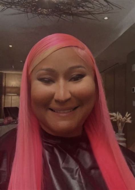 A Woman With Pink Hair Is Smiling At The Camera