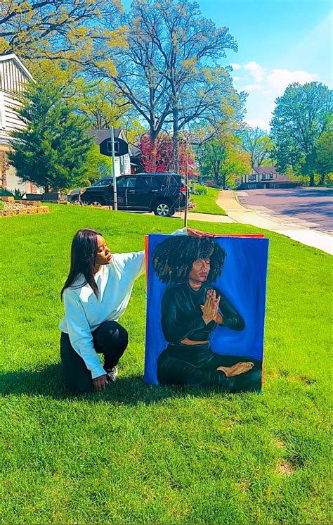 A Woman Kneeling Down Next To A Painting On The Grass