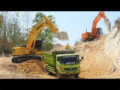 There Are Two Trucks That Are Digging Dirt