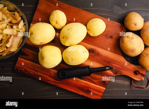 Peeled Yukon Gold Potatoes On A Wooden Cutting Board Peeled And