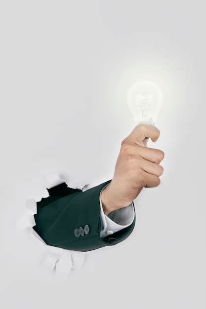 Premium Photo Cropped Hand Of Man Holding Light Bulb Coming Out From