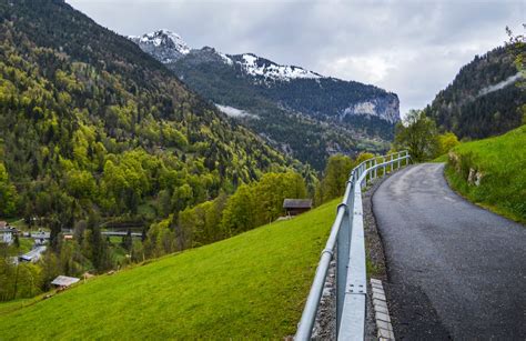 Road and fence on green mountain slope · Free Stock Photo