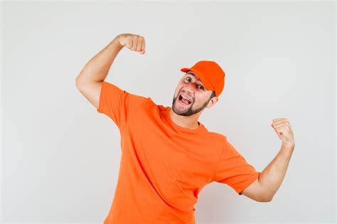 Free Photo Delivery Man In Orange T Shirt Cap Showing Winner Gesture