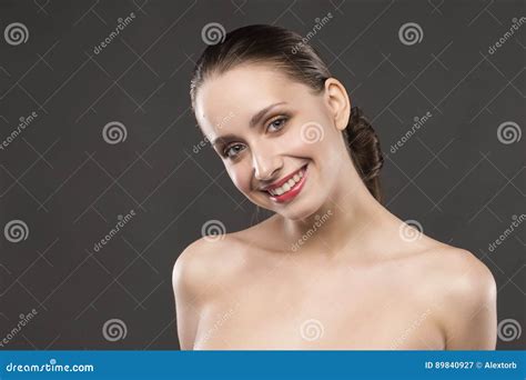 Le Spalle Nude Della Bella Ragazza Sorride Su Un Fondo Grigio Immagine