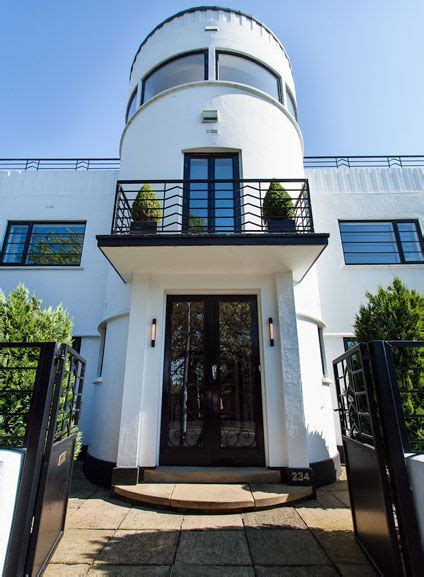 The Entrance To A Large White Building With Black Doors And Railings On