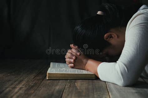 Hands Folded In Prayer On A Holy Bible In Church Concept For Faith