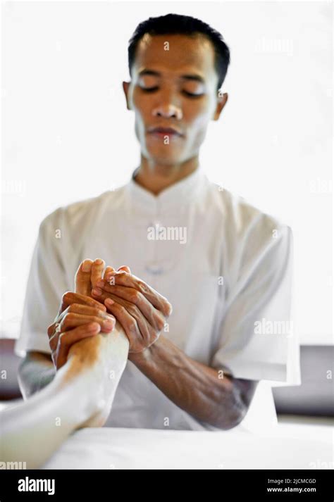 Balinese Male Spa Therapist Giving Foot Refloxology Massage At Ayung