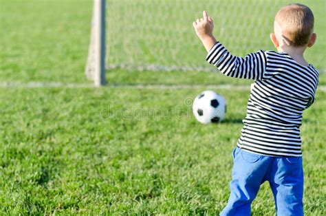 Muchacho Joven Que Golpea Un Balón De Fútbol Con El Pie Foto de archivo