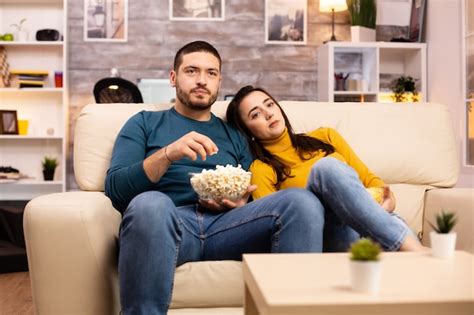 Premium Photo Handsome Couple At Home Eating Pop Corn And Watching Tv