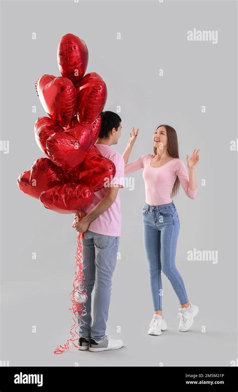 Young Couple In Love With Balloons On Light Background Valentines Day