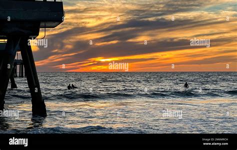 Colorful sunset lights up the beach, pier and ocean in Los Angeles ...