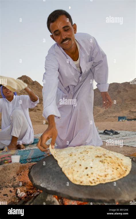 A Bedouin Man Cooking Bread On An Open Fire In A Camp In The Sinai