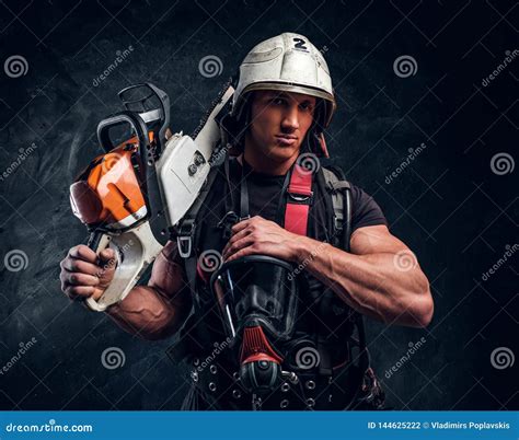 Portrait Of Muscular Man With Chainsaw And Respirator Stock Photo