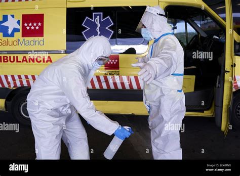 Los trabajadores de ambulancias desinfectan sus trajes de protección