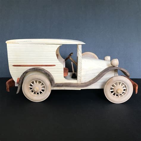 An Old Fashioned Wooden Toy Car On A Black Surface