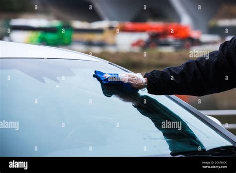 Hand Cleaning A Cars Windshield With A Micro Fiber Cloth Washing