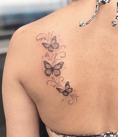 The Back Of A Woman S Shoulder With Butterfly Tattoos On Her Left Arm