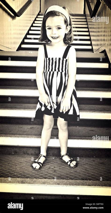 Little girl in striped dress on steps Stock Photo - Alamy