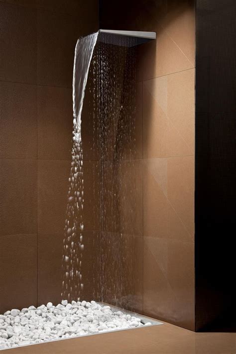 A Shower Head With Water Coming Out Of It S Side And Rocks On The Floor