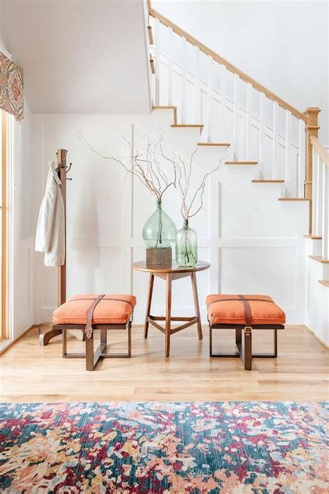 Entryway Features Two Orange Leather Strap Stools At A Round Entry