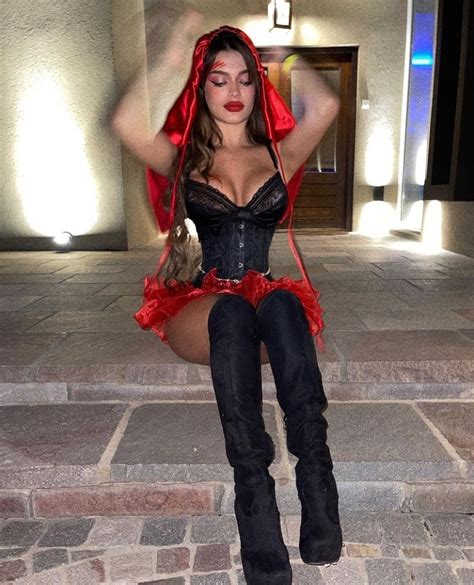 A Woman In A Corset And Boots Posing For The Camera