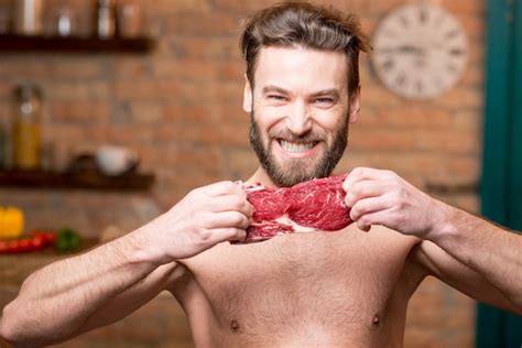 Premium Photo Portrait Of A Naked Muscular Man Tearing Raw Meat On