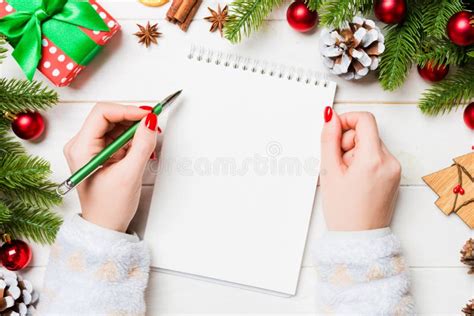 Vista De Cima Da Mão Feminina Num Caderno Sobre O Fundo De Natal De