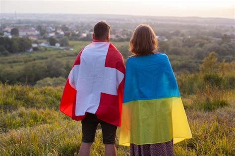 Premium Photo Couple Covered In Ukraine And Switzerland Flags