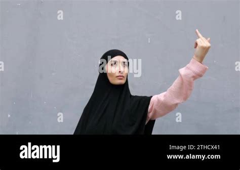 Brash Brave Muslim Woman In Hijab With Hand Stretched High Upwards Provocatively Shows Her