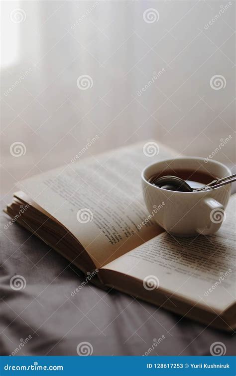 Cozy Home Still Life Cup Of Hot Tea With Sieve And Opened Book On Grey