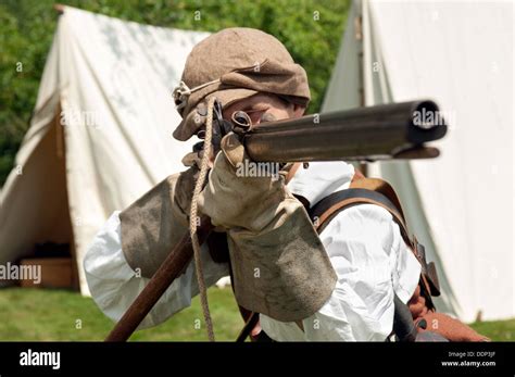 17th Century Civil War Musketeer In Period Dress Aiming A Matchlock