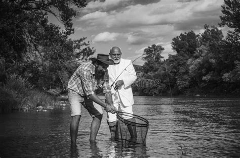 Two Men Friends Fisherman Fishing On River Old Father And Son Anglers