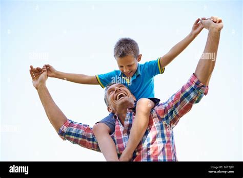 La Fierté Et La Joie Des Pères Une Photo Sous Angle Dun Père Heureux Portant Son Jeune Fils