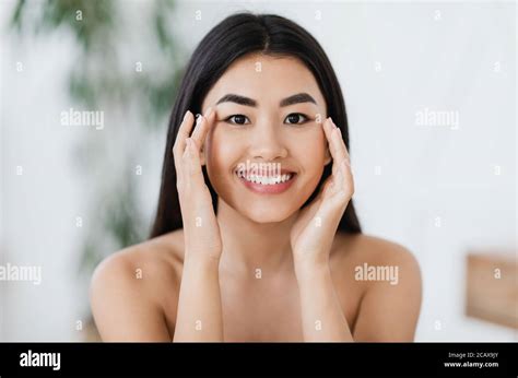 Attractive Smiling Asian Woman Rubbing Massaging Her Eye Zone Stock