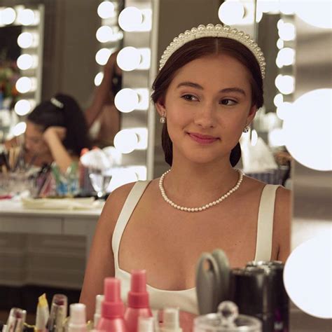 a woman in a white dress is looking at the camera and smiling while she ...