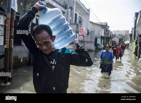 Bandung, Indonesia. 27th Apr, 2023. People wade through flood water due ...