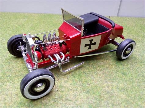 A Red And Black Toy Car Sitting On Top Of A Green Floor