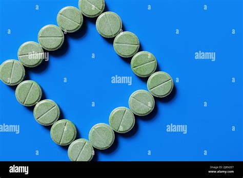 Top View Of Green Pills In Shape Of Rhombus On Bright Blue Background