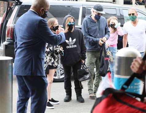 A Group Of People Standing Around Each Other In Front Of A Van And